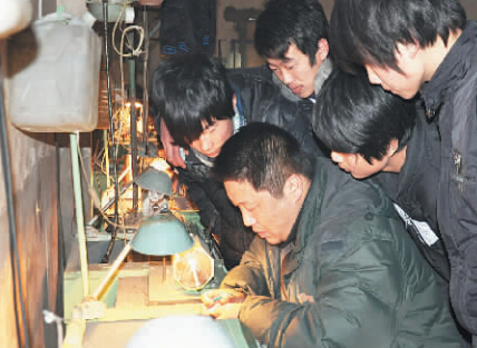 雷铭正在向学徒传授玉雕技艺。